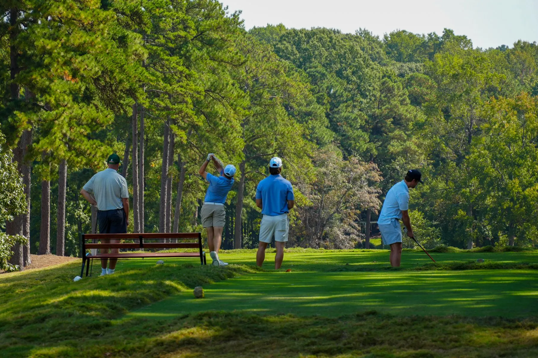 Golfers teeing off among the pines at North Ridge Country Club during the Capital City Golf Classic.